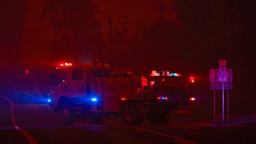 A fire truck leaves the local RFS station as thick smoke turns the town into darkness on January 04, 2020 in Bodalla, Australia. 