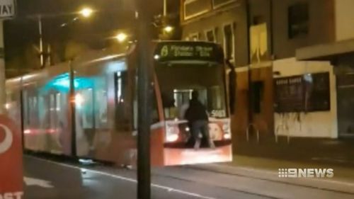 A man tram-surfing in Melbourne.