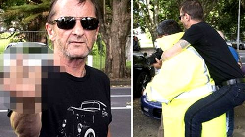 Phil Rudd flips the bird to waiting media as he leaves court in Tauranga, New Zealand. (AFP)