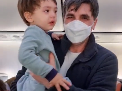 Parikshit Balochi holding the crying toddler on board the passenger flight.