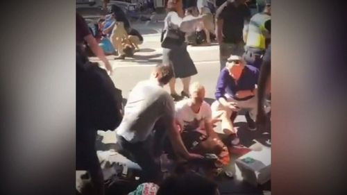 Bec is supported by bystanders in this image of the Flinders Street aftermath.