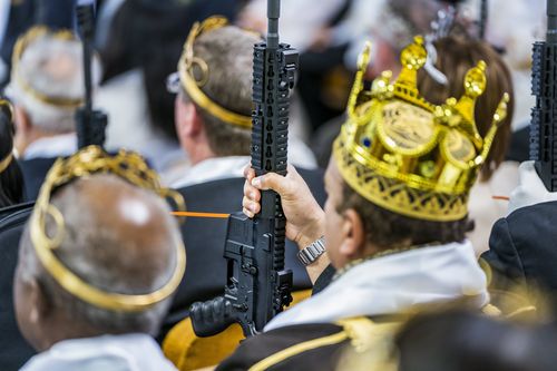 Wearing crowns and clutching their guns, worshippers gathered at the World Peace and Unification Sanctuary. (AAP)