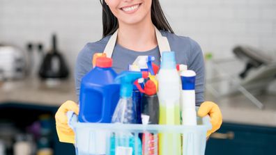 Woman holding cleaning supplies