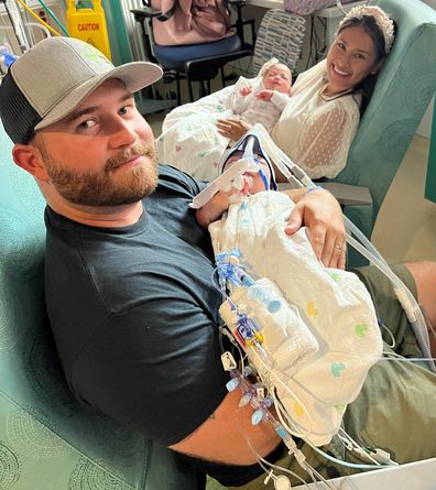 Sandy and Jesse each holding their twin daughters after their marathon six hour surgery.