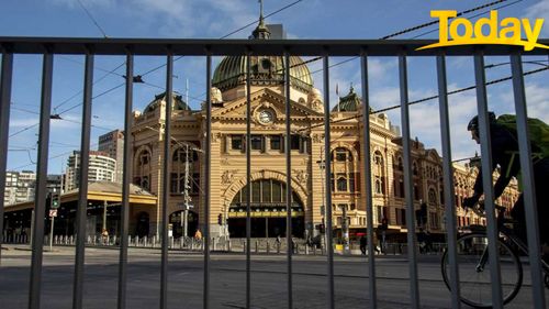A cyclist passes an empty Flinders Street Station during lockdown due to the continuing spread of the coronavirus in Melbourne.