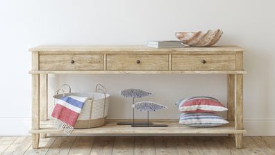 Interior in coastal style. Console table near empty white wall.