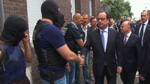Mr Hollande shakes hands with police in Normandy after the church attack which saw a priest killed. (AAP)