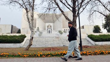 A pedestrian walks past the Supreme Court building in Islamabad on January 17, 2013. (AFP)