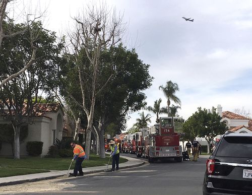 Crews clean up where a helicopter crashed into a house in Newport Beach yesterday. (AAP)