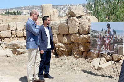 Prince William and Jordanian Crown Prince Hussein look at a photograph showing William's wife, the former Kate Middleton, her father Michael and younger sister Pippa in the ruins of the Roman city of Jerash in the 1980s. (AAP)