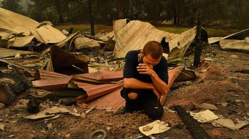 Karl Niehus unearths Water Dragon eggs from the ruins of his mother's business in Mogo's Main Street that was destroyed by the fire that swept through the town.