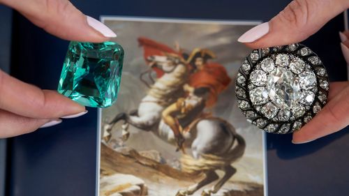 Sotheby's çalışanı, 1804 taç giyme töreninde Napolyon'un giydiği söylenen yeşil beryl ve Napolyon'a ait bir elmas broşu sergiliyor.