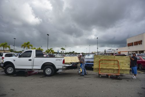 Men load recently purchased wood panels to be used for boarding up windows in preparation for Hurricane Irma, in Carolina, Puerto Rico. (AP)