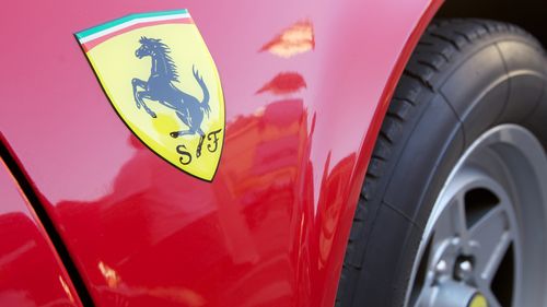 Close up to the famous Ferrari logo on flaming red Ferrari 360 Modena parked in a Faenza square in Italy. 