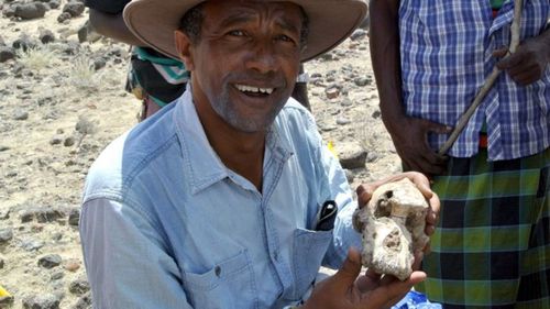 Yohannes Haile-Selassie is pictured with the fossil skull of Australopithecus anamensis.