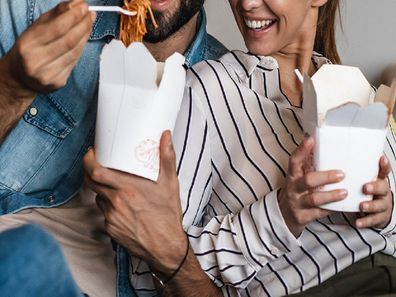 Couple at home eating takeaway