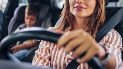 Mother driving her young son to school in a car