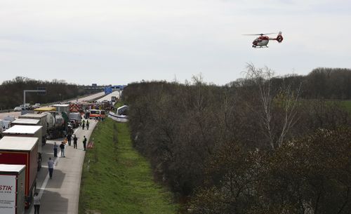 Emergency vehicles and a rescue helicopter work at the scene of the accident on the A9, near Schkeuditz, Germany, Wednesday, March 27. 2024 