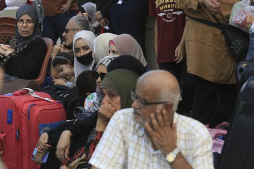 Palestinians wait at the Rafah border crossing between the Gaza Strip and Egypt Gaza Strip on Saturday, Oct. 14, 2023 