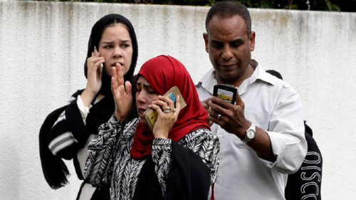 People wait outside a mosque in central Christchurch, New Zealand. 