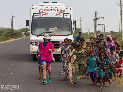 Local children running alongside Samantha during her ultra-marathon journey across India.