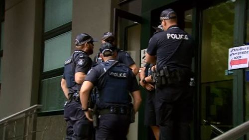 Officers gather outside the QPS building. (9NEWS)