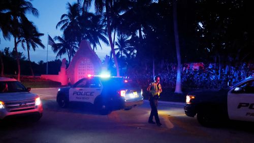 Police direct traffic outside an entrance to former President Donald Trump's Mar-a-Lago estate during a raid