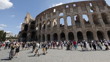 Tourists wait in a queue to enter the Colosseum in Rome, Italy.