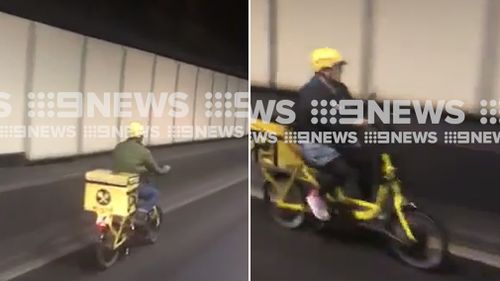 Two delivery drivers on electric bikes have been caught on camera driving through Sydney's busy Eastern Distributor tunnel. (Supplied)