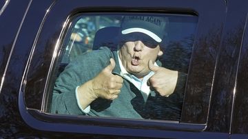 President Donald Trump gives two thumbs up as he departs after playing golf at the Trump National Golf Club.