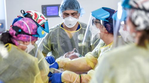 A team of doctors and nurses work on a COVID-19 patient in a Melbourne ICU ward.