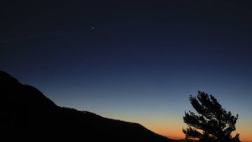 Saturn, top, and Jupiter, below, are seen after sunset from Shenandoah National Park, in Virginia. The two planets are drawing closer to each other in the sky as they head towards a &quot;great conjunction&quot; on December 21, where the two giant planets will appear a tenth of a degree apart.