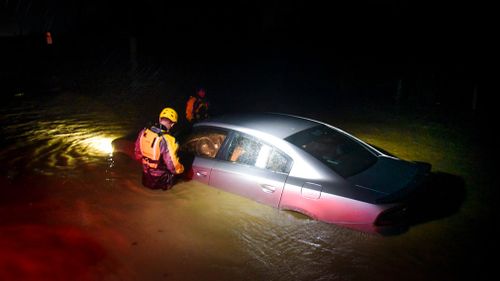 Rescue staff from the Municipal Emergency Management Agency investigate an empty flooded car during the passage of Hurricane Irma through the northeastern part of the island in Fajardo, Puerto Rico. (AP)