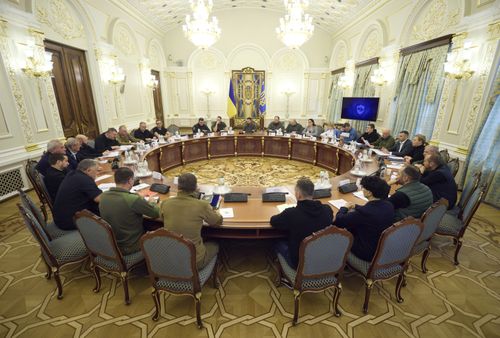 Ukrainian President Volodymyr Zelenskyy, background centre, leads a meeting of the National Security and Defense Council in Kyiv, Ukraine, Friday, Sept. 30, 2022. 