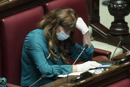 Politician  Maria Teresa Baladini wears a face mask and gloves during a session in parliament on financial relief. Picture: Roberto Monaldo.