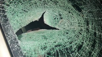 A car windscreen shattered by a rock.