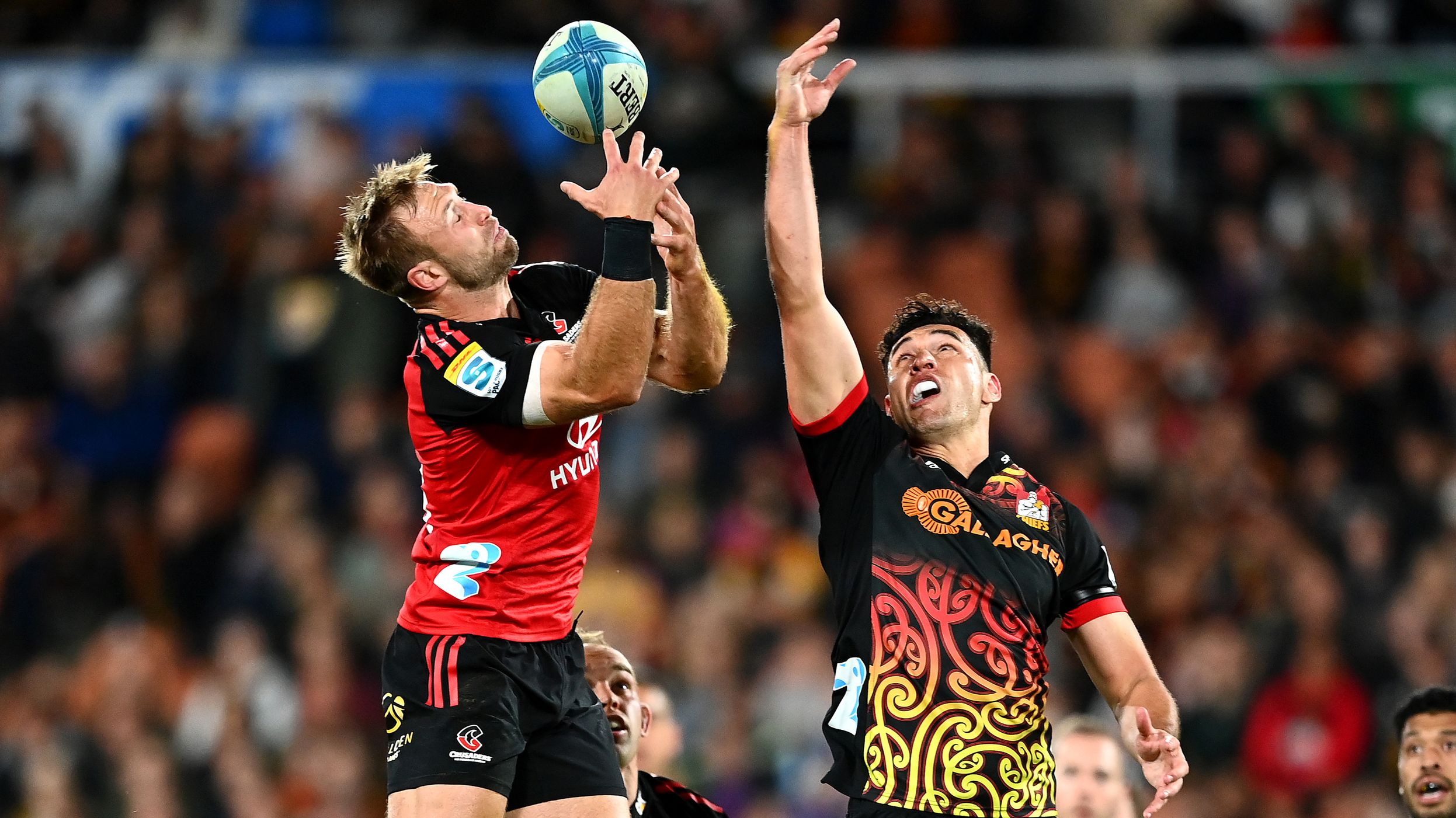 Braydon Ennor of the Crusaders and Shaun Stevenson of the Chiefs compete for the ball during round 10 of Super Rugby Pacific.