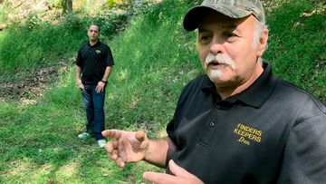 Dennis Parada, right, and his son Kem Parada stand at the site of the FBI&#x27;s dig for Civil War-era gold in Dents Run.