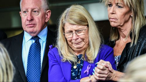 Faye Leveson (centre) is supported by her husband Mark Leveson (left) and a friend at the NSW Coroner's Court. (AAP)