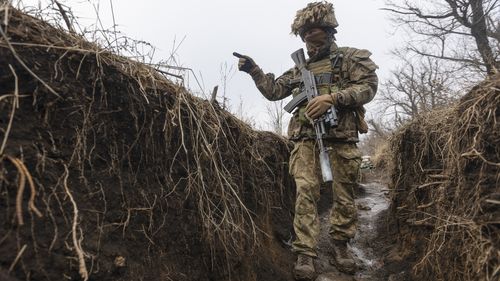 A Ukrainian soldier walks in a trench at the line of separation in Ukraine. 