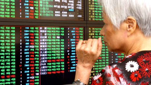 A woman anxiously surveys the market's reaction to the Brexit in Taiwan. (AAP)