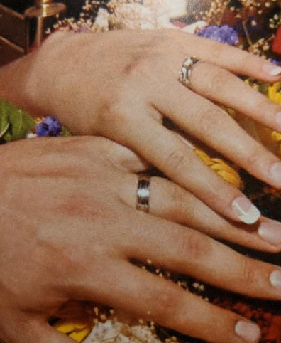 A photo of the couple wearing their rings on their wedding day.