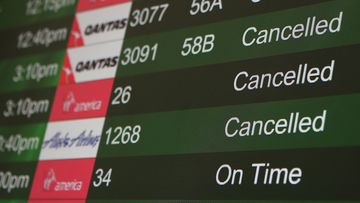 Cancelled flights due to weather are displayed on a departure monitor at San Francisco International Airport