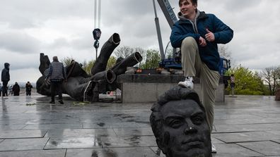 A young man poses with his foot on a head from the The &#x27;Friendship of Peoples&#x27; monument during its demolition on April 26, 2022 in Kyiv, Ukraine. Kyiv&#x27;s Mayor Vitali Klitschko announced in a social media post that the 8-meter high statue of men holding a star-shaped emblem that says &quot;Friendship of Peoples&quot; and &quot;USSR&quot; would be removed from the city, and the metal arch overhead would be renamed. 