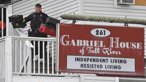 A law enforcement official removes boxes containing patient medications from the Gabriel House assisted living facility following a fire that resulted in multiple fatalities, in Fall River, Mass., Monday, July 14, 2025. (AP Photo/Steven Senne)