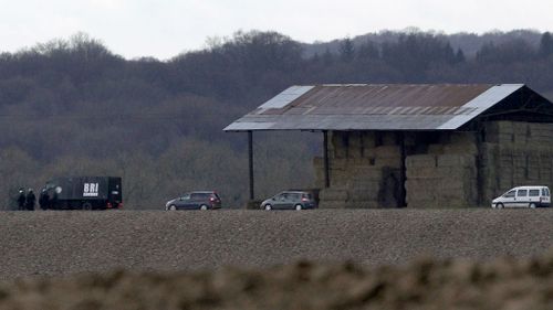 French armed police officers patrol near a farm as they search for suspects. (AAP)