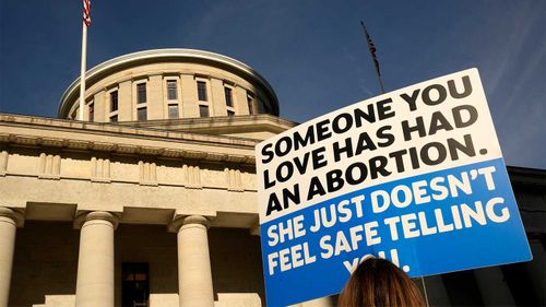 A protester holds a sign outside the Ohio State Capitol in Columbus, where a 10-year-old was allegedly raped and impregnated.