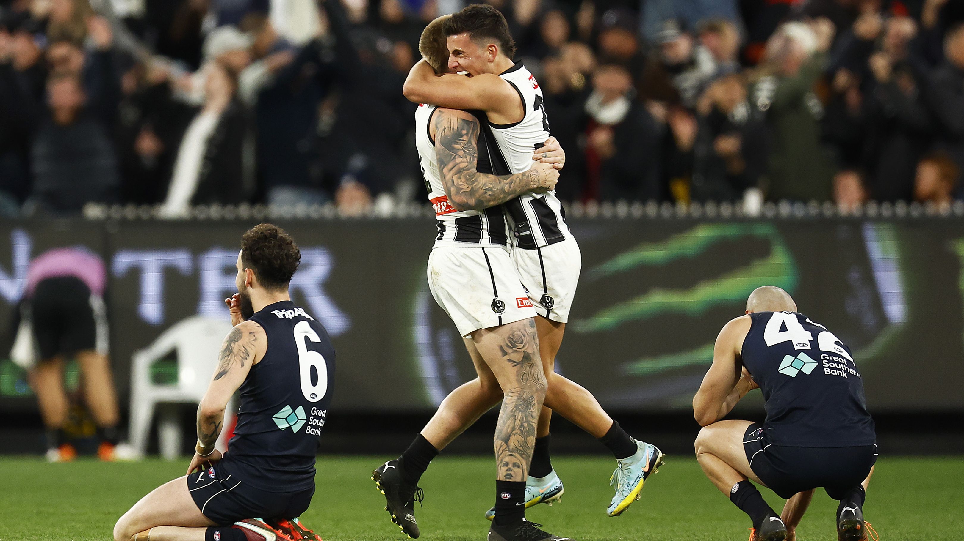 Zac Williams of the Blues (L) and Adam Saad of the Blues look dejected as Jordan De Goey of the Magpies and Nick Daicos of the Magpies celebrate on the final siren.