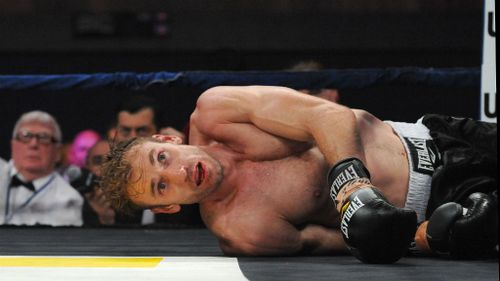 Shane Tuck lies on the canvas after being floored by a punch. (AAP)