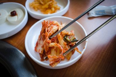 Kimchi in a bowl with chopsticks